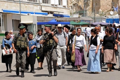 Israeli border police guard a group of Israeli tourists visiting Hebron in April 2014.
