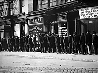 Unemployed men queuing for coffee and bread at a soup kitchen run by the Bahai Fellowship at 203 East 9th Street, New York, circa 1930.