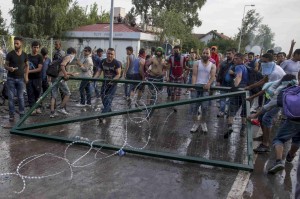 Migrants remove a barrier during clashes with Hungarian riot police at the border crossing with Serbia in Roszke